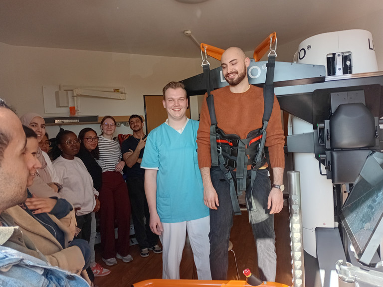 Auszubildende des BPA 02-25 der Beruflichen Pflegeausbildung testen im Albertinen Krankenhaus gemeinsam mit Physiotherapeut Tim Göldner den Gangtrainer Lexo im Rahmen des Unterrichts zu digitalen und technischen Unterstützungssystemen in der neurologischen Frührehabilitation. Auszubildende des BPA 02-25 der Beruflichen Pflegeausbildung testen im Albertinen Krankenhaus gemeinsam mit Physiotherapeut Tim Göldner den Gangtrainer Lexo im Rahmen des Unterrichts zu digitalen und technischen Unterstützungssystemen in der neurologischen Frührehabilitation.